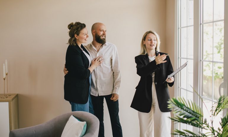 Agent immobilier faisant la démonstration d’un nouvel appartement à un couple heureux